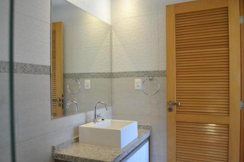 un baño con lavabo y espejo en Praia do Forte, Piscinas Naturais, en Praia do Forte