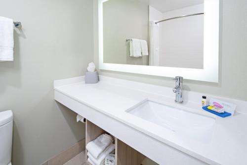 La salle de bains blanche est pourvue d'un lavabo et d'un miroir. dans l'établissement Holiday Inn Express Hotel & Suites Watsonville, an IHG Hotel, à Watsonville
