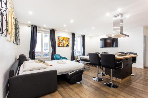 Cette chambre comprend un lit, un bureau et des chaises. dans l'établissement BASTILLE/LE MARAIS-LUXURIOUS 3 rooms flat, à Paris