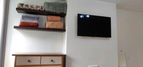 a room with a tv and towels on a wall at The Hideaway in London in London