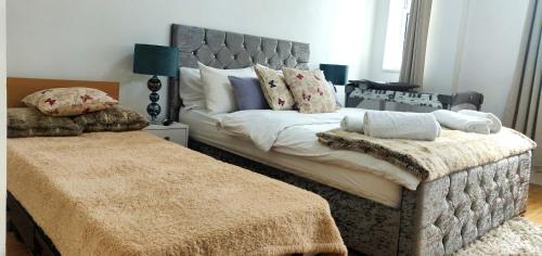 a bedroom with a large bed with a gray headboard at Insignia Moment, London in London