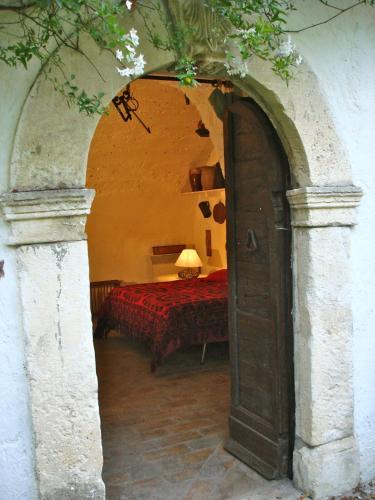 an archway leading to a bedroom with a red bed at Agriturismo "Borgo Madonna degli Angeli" - charming cottages in the gardens ! in Tocco da Casauria