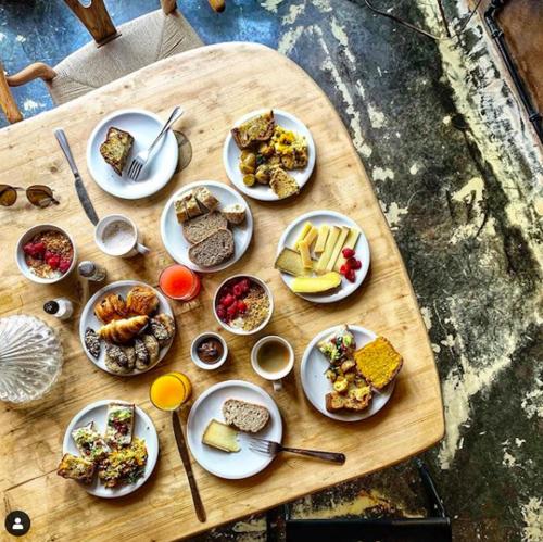 a wooden table with plates of food on it at Hôtel La Nouvelle République & Hammam in Paris