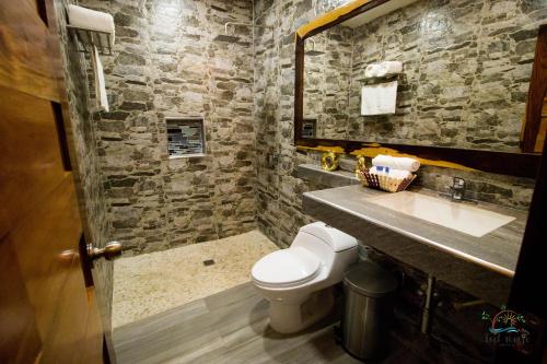 een stenen badkamer met een toilet en een wastafel bij isel magic hotel in Bacalar