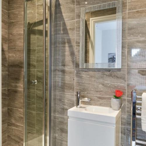 a bathroom with a sink and a glass shower at Priory Suites in Liverpool