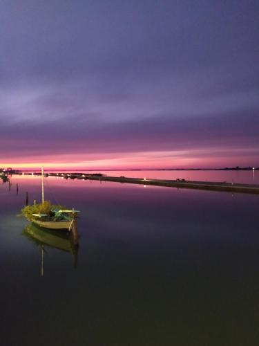a boat sitting in the water at sunset at Katsenos studios in Nikiana