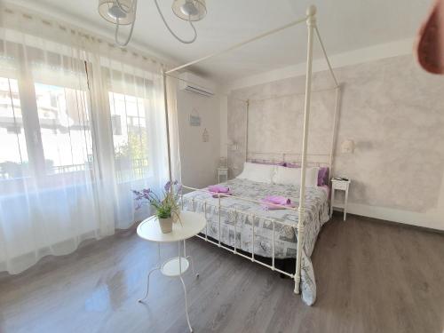 a bedroom with a canopy bed and a table at Terry's House in Nuoro