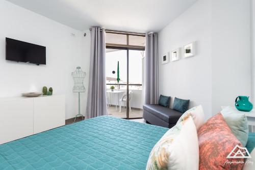 a bedroom with a bed and a couch and a television at Alojamiento Alby: Oceano in Los Cristianos