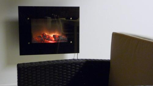 a laptop computer sitting in front of a fireplace at Karemajat Cottage Resort in Ylitornio
