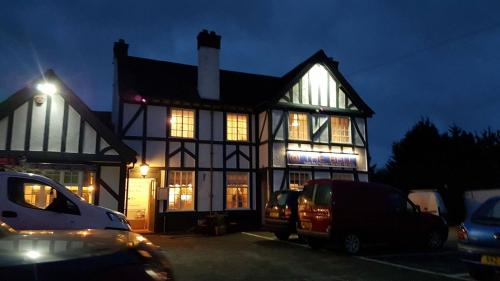 a building with cars parked in a parking lot at night at Bell Inn in Evesham