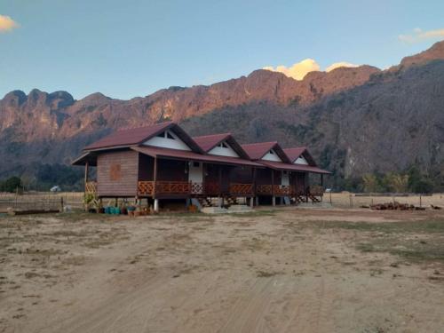 a large building with mountains in the background at Konglor Eco-Lodge Guesthouse and Restaurant in Ban O