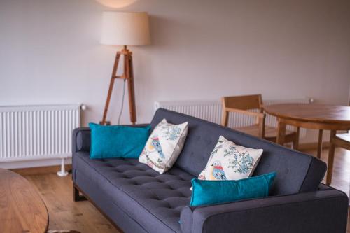a living room with a blue couch with pillows at Line Hotel Patagonia in Puerto Natales