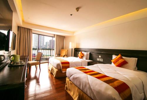 Century Park Hotel في مانيلا: غرفه فندقيه سريرين وتلفزيون