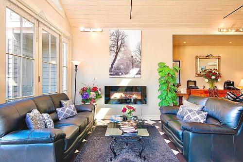 a living room with two leather couches and a tv at Kurrajong House in Launceston