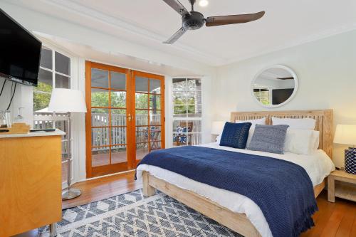 a bedroom with a bed and a flat screen tv at The Odd Gecko B&B in Canungra