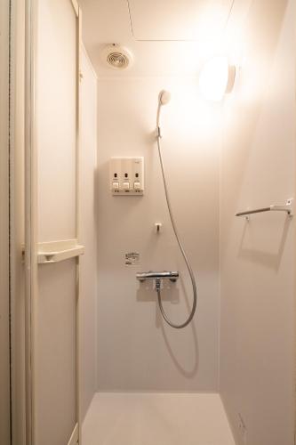 a shower in a bathroom with a glass door at Hotel Owl Tokyo Shinbashi in Tokyo