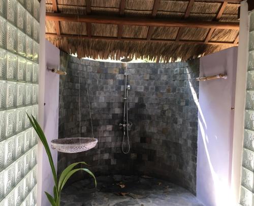 bagno con doccia in un muro di mattoni di Le Domaine De Tam Hai Resort ad An Hòa