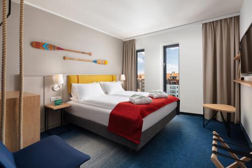 a hotel room with a bed with a red blanket at Holiday Inn Gdansk - City Centre by IHG in Gdańsk