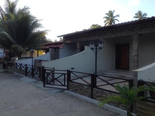 a house with a gate and a fence at Chalés Caribe brasileiro - Chale 2 in Maragogi
