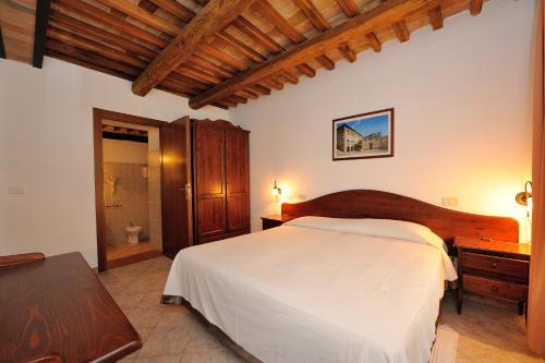 a bedroom with a large white bed and a table at Agriturismo Belsito Pian Di Boccio in Bevagna