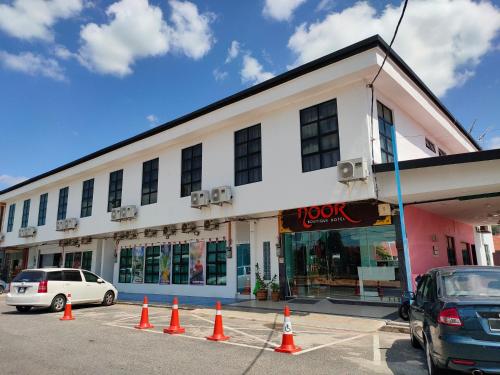 a white building with orange cones in front of it at Noor Boutique Hotel in Kuala Perlis