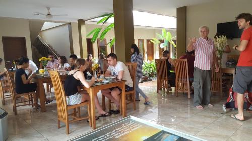people sitting around a dining room table at Aloha Hotel Yogyakarta in Yogyakarta