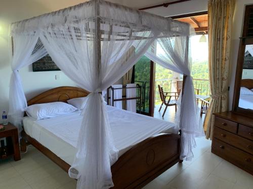a bedroom with a canopy bed and a balcony at Lotus Villa Kandy in Peradeniya