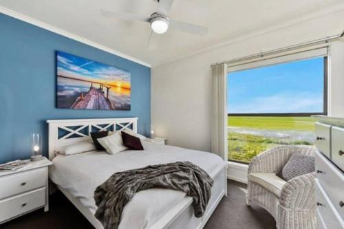 a bedroom with a bed and a large window at Plovers Rest at Cape Douglas in Cape Douglas