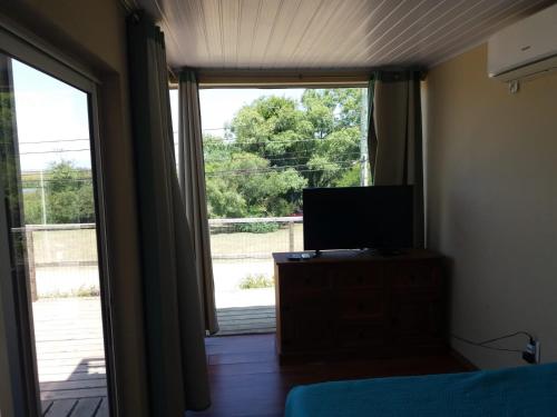 a bedroom with a television and a large window at Naturaleza pura in Rocha