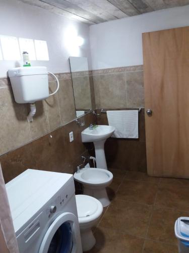 a bathroom with a toilet and a sink and a washing machine at Naturaleza pura in Rocha