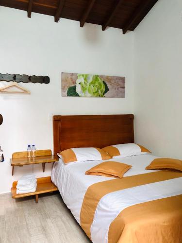 a bedroom with two beds and a wooden headboard at 40 Amigos Hotel in Jardin