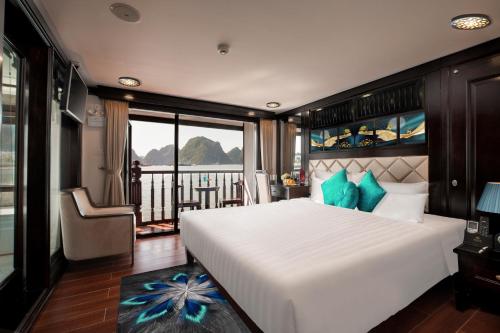 a bedroom with a large white bed and a balcony at Alisa Premier Cruise in Ha Long