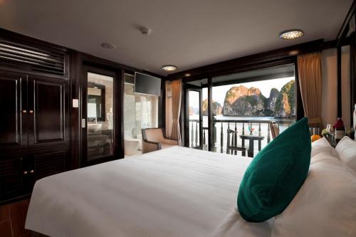 a bedroom with a large bed with a large window at Alisa Premier Cruise in Ha Long