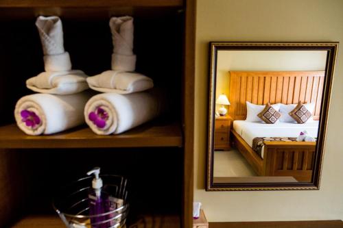 a bedroom with a bed and a mirror and towels at Paholyothin Park Place in Bangkok