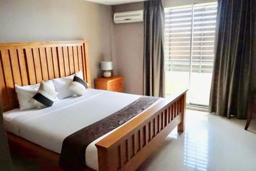 a bedroom with a large bed and a large window at Paholyothin Park Place in Bangkok