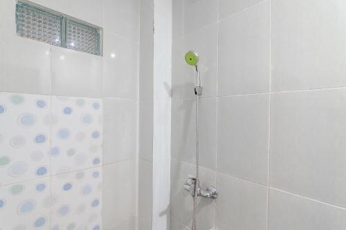 y baño blanco con ducha. en RedDoorz at Rajawali KM 5 Palangkaraya en Palangkaraya