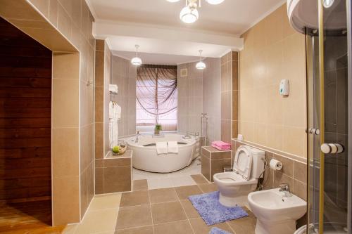 a bathroom with a tub and a toilet and a sink at Hotel Aurora Plus in Bulan Sogottuu