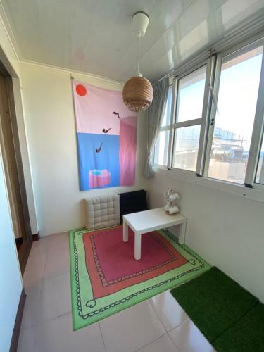 a living room with a white table and a red rug at 好事好室Goodthings in Xiaoliuqiu