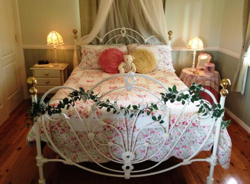 sypialnia z łóżkiem z pluszowym misiem w obiekcie Milford Country Cottages w mieście Milford