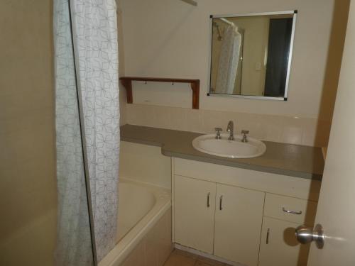 a bathroom with a sink and a mirror and a tub at Townsville Terrace in Townsville