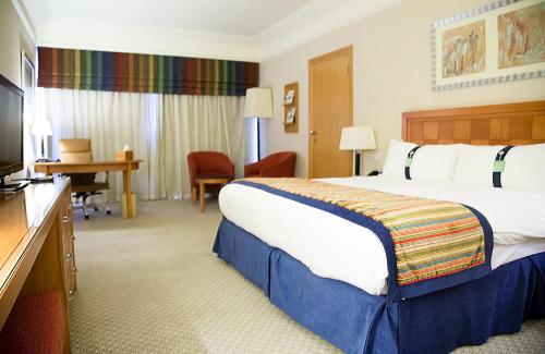 a hotel room with a large bed and a television at Holiday Inn Citystars by IHG in Cairo