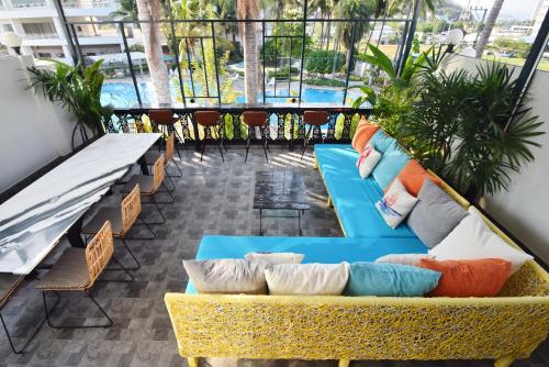 a balcony with couches and chairs and a pool at Blu Beach Haven in Hua Hin