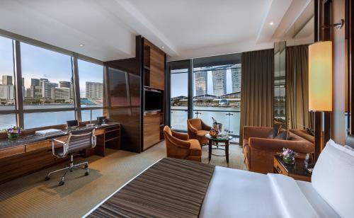 a living room filled with furniture and a large window at The Fullerton Bay Hotel Singapore (SG Clean, Staycation Approved) in Singapore