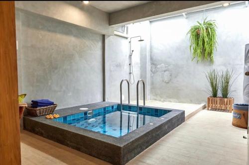 a bathroom with a hot tub in a room at Vann House Hua Hin in Hua Hin