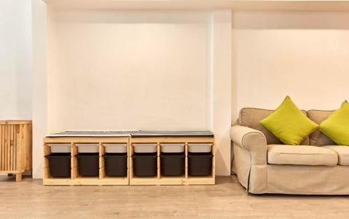 a living room with a couch and yellow pillows at Vann House Hua Hin in Hua Hin