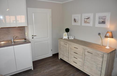 a kitchen with white cabinets and a wooden counter top at Bellevue 02 in Laboe