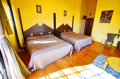 two beds in a room with yellow walls and wooden floors at 南投清境挪威森林 in Renai