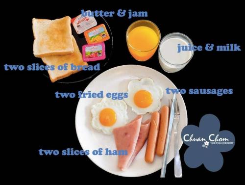 a plate of breakfast food with eggs and bread and orange juice at Hotel Chuan Chom The High Resort Saraburi - SHA Plus in Sara Buri