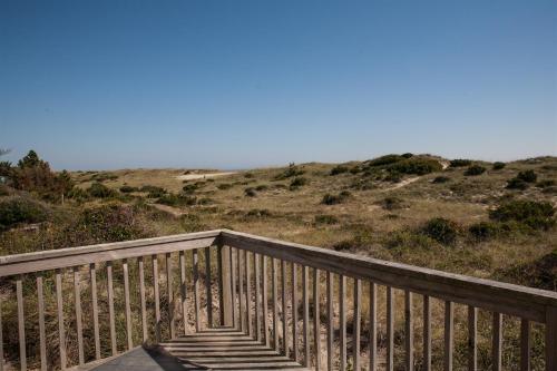 a wooden boardwalk leading to the ocean on the beach at 40399 Beachcomber Rd Home in Avon