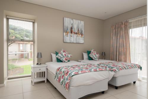 a bedroom with two beds and a window at 65A Zimbali Wedge in Ballito
